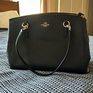 Coach handbag - black leather with gold accents, shoulder strap, zip pockets